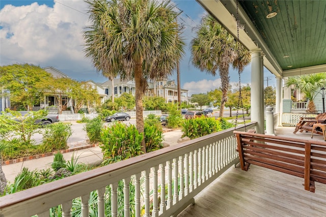 wooden deck with covered porch and a residential view