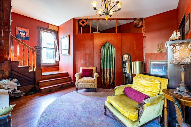 living area with an inviting chandelier, wood finished floors, and stairway