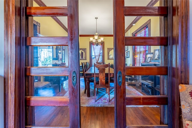 dining room featuring a notable chandelier, ornamental molding, and hardwood / wood-style flooring