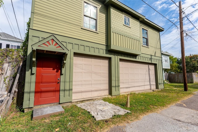 view of property with a garage, fence, and board and batten siding