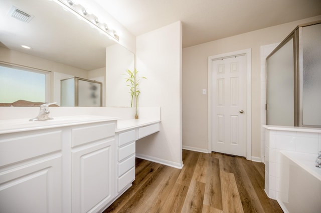 4609 Buescher Ct, Pearland, TX 77584 - bathroom with wood finished floors, baseboards, visible vents, a stall shower, and a garden tub