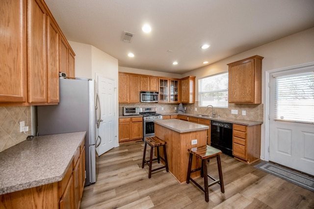 4609 Buescher Ct, Pearland, TX 77584 - kitchen featuring a kitchen bar, visible vents, stainless steel appliances, and tasteful backsplash