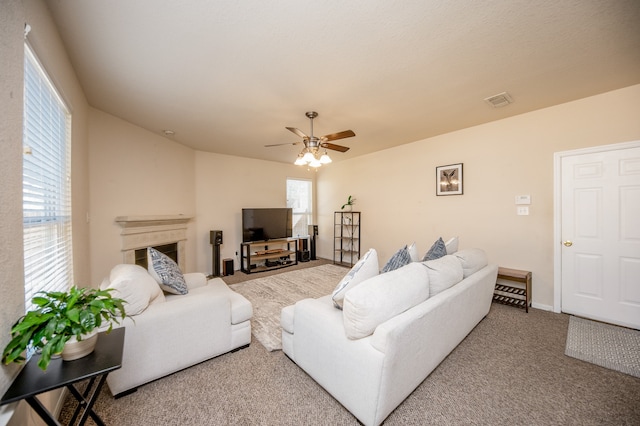 carpeted living room with ceiling fan