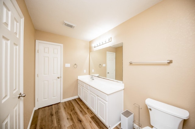 4609 Buescher Ct, Pearland, TX 77584 - half bath featuring visible vents, baseboards, toilet, wood finished floors, and vanity