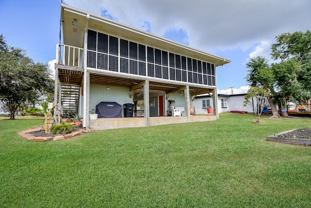 rear view of house with a patio area, a sunroom, and a yard