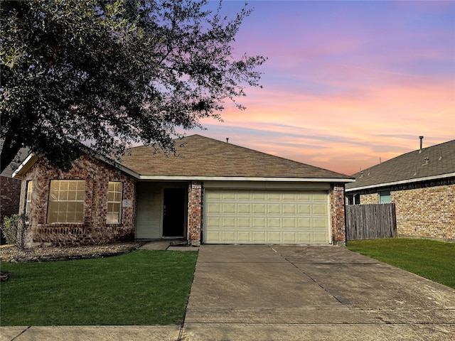 ranch-style home with a yard and a garage