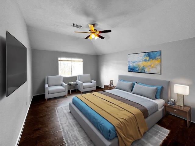 bedroom featuring dark hardwood / wood-style flooring, a textured ceiling, ceiling fan, and vaulted ceiling