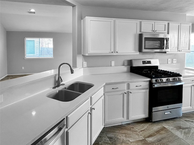 kitchen featuring white cabinetry, stainless steel appliances, sink, and a wealth of natural light