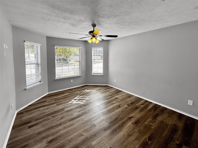 empty room featuring ceiling fan, a textured ceiling, and dark hardwood / wood-style floors