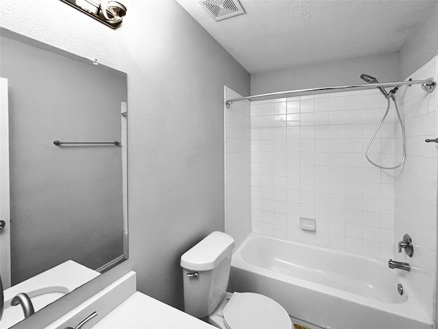 full bathroom with toilet, tiled shower / bath combo, a textured ceiling, and vanity