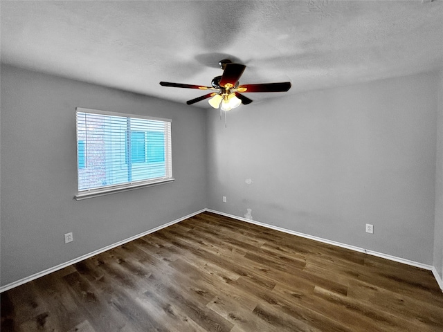 empty room with dark hardwood / wood-style floors, a textured ceiling, and ceiling fan