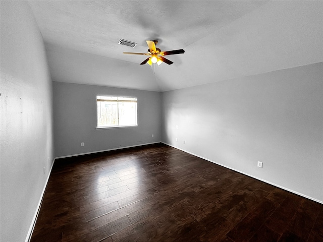 spare room featuring ceiling fan, a textured ceiling, vaulted ceiling, and dark hardwood / wood-style floors