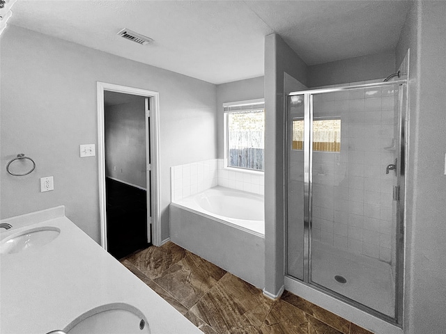 bathroom with vanity and shower with separate bathtub