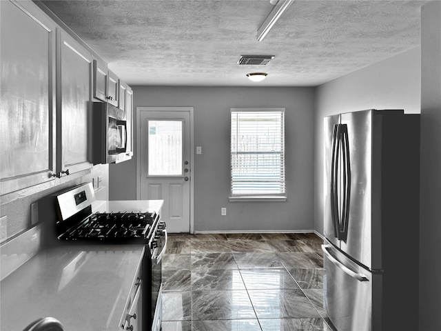 kitchen featuring appliances with stainless steel finishes and a textured ceiling