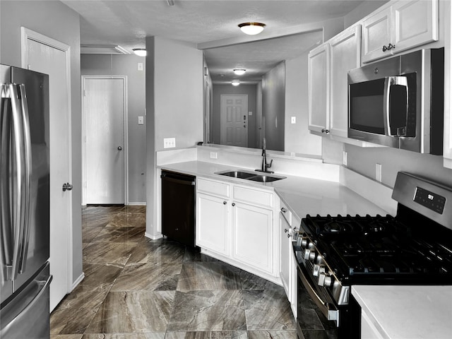 kitchen featuring white cabinets, stainless steel appliances, sink, and a textured ceiling