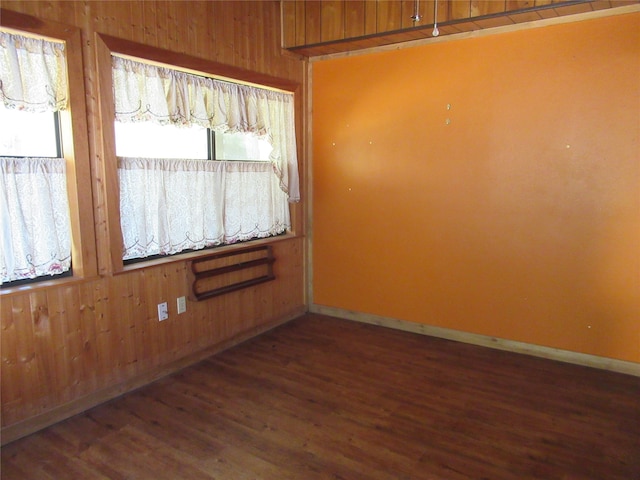 empty room featuring dark hardwood / wood-style floors and wooden walls