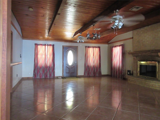 unfurnished living room with beam ceiling, ceiling fan, dark tile patterned flooring, and wooden ceiling