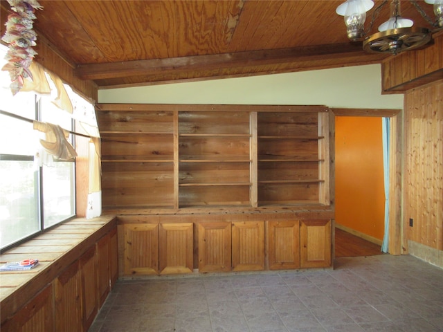 unfurnished living room with vaulted ceiling with beams, a notable chandelier, wood walls, and wooden ceiling