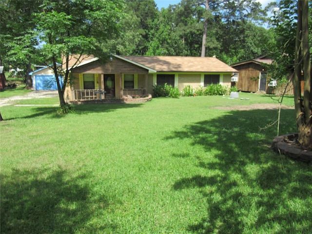 372 Creekside Dr, Onalaska, TX 77360 - single story home with covered porch, a front lawn, a detached garage, and driveway