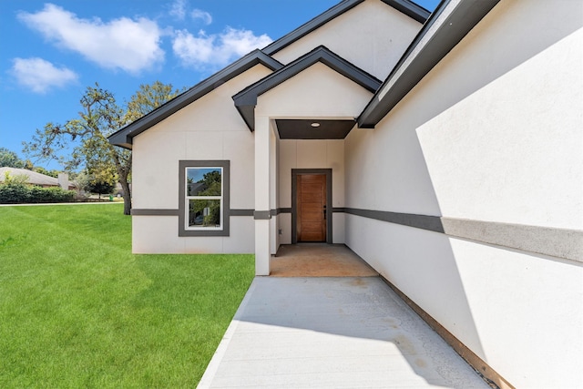 view of exterior entry featuring a yard