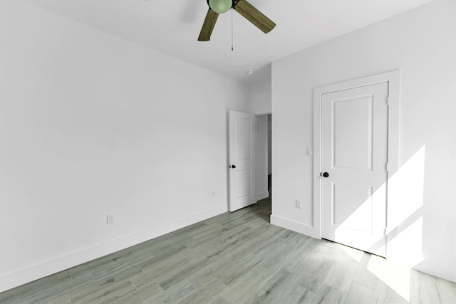 unfurnished bedroom with ceiling fan and light wood-type flooring