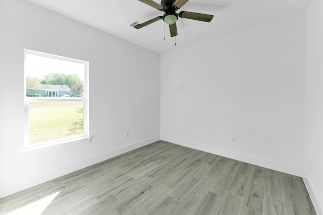 unfurnished room with a wealth of natural light, ceiling fan, and light hardwood / wood-style flooring