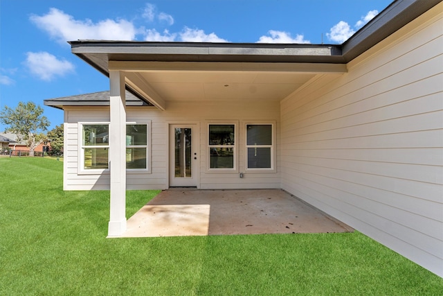 entrance to property featuring a yard and a patio area