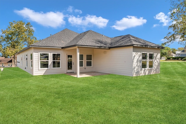 rear view of house featuring a lawn and a patio