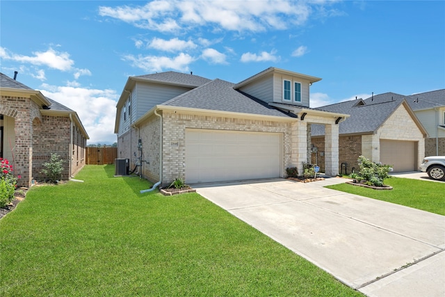 view of front of house featuring central air condition unit, a front yard, and a garage