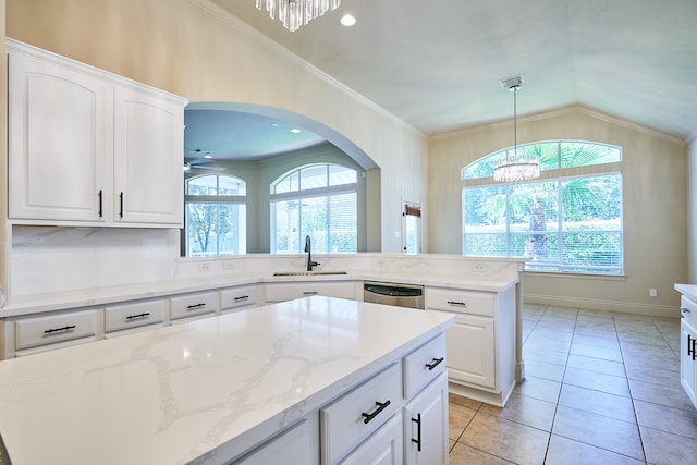 kitchen featuring lofted ceiling, sink, white cabinetry, and a center island