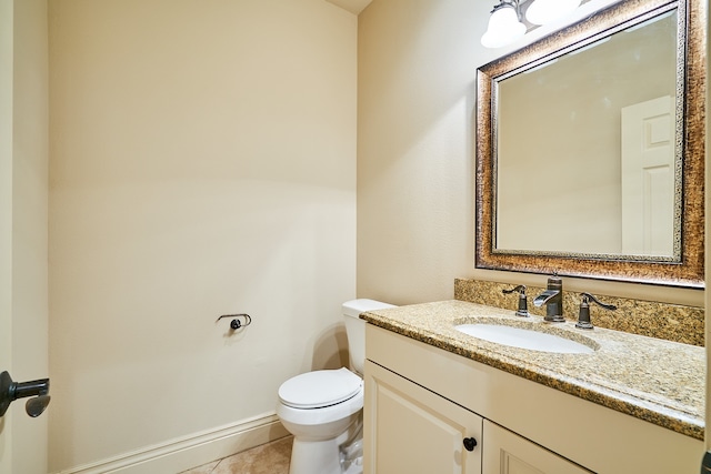 bathroom with toilet, vanity, and tile patterned flooring