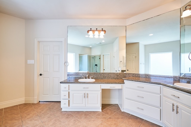 bathroom featuring vanity, a shower with shower door, and tile patterned flooring