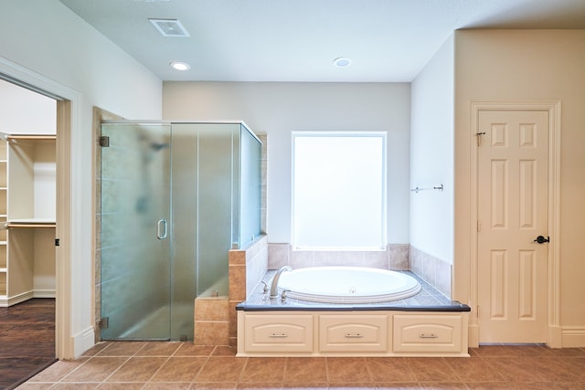 bathroom with tile patterned flooring and shower with separate bathtub