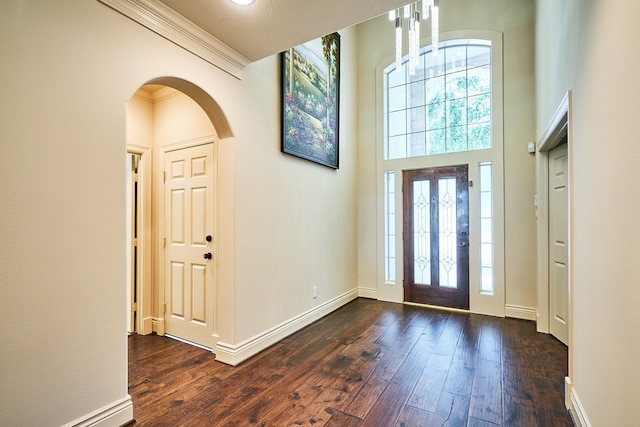 entryway featuring crown molding, a textured ceiling, and dark hardwood / wood-style flooring