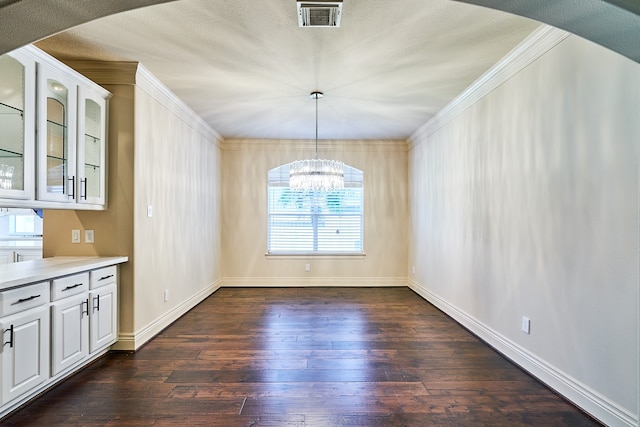 unfurnished dining area featuring dark wood-type flooring, a wealth of natural light, and an inviting chandelier