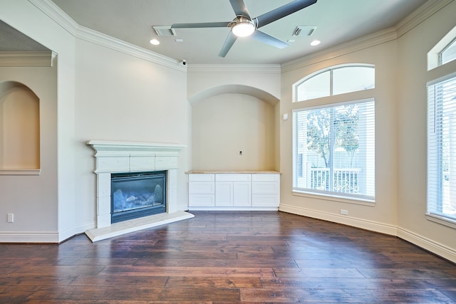 unfurnished living room featuring crown molding, dark wood-type flooring, a fireplace, and ceiling fan