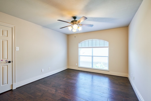 spare room featuring dark wood-type flooring, ceiling fan, and a textured ceiling