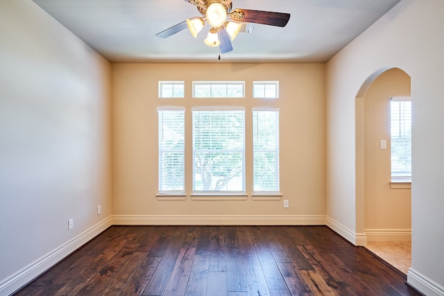 empty room with ceiling fan and dark hardwood / wood-style flooring