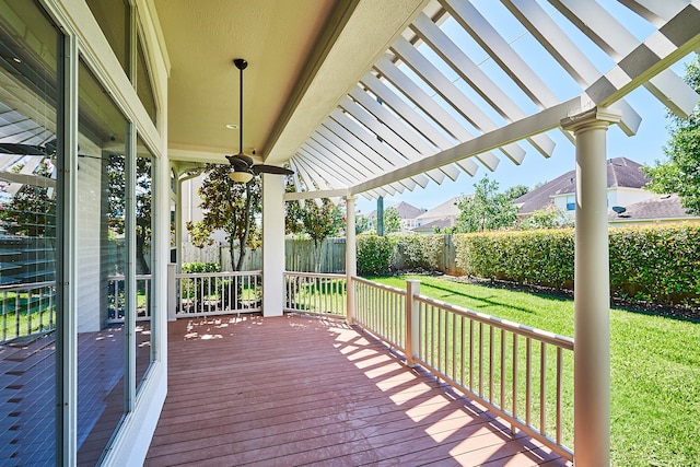 wooden deck with ceiling fan, a lawn, and a pergola