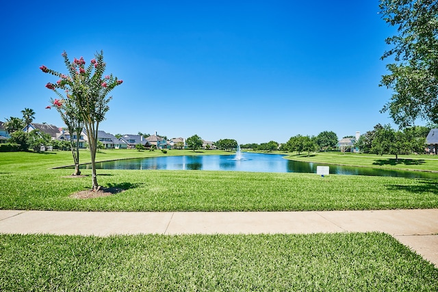 view of home's community with a lawn and a water view