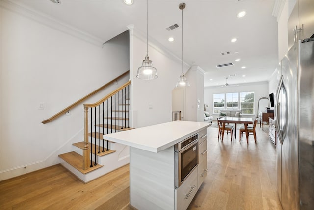 kitchen featuring a center island, hanging light fixtures, stainless steel appliances, and light hardwood / wood-style floors