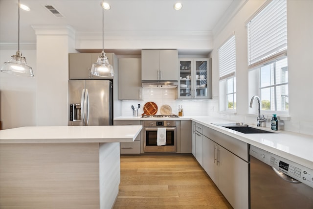 kitchen featuring gray cabinetry, stainless steel appliances, sink, and hanging light fixtures