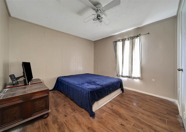 bedroom featuring ceiling fan, a textured ceiling, and dark hardwood / wood-style flooring