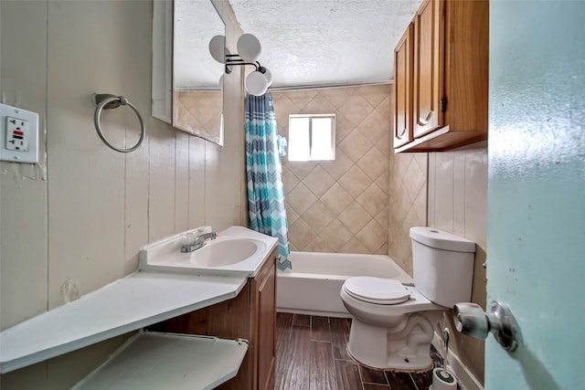 full bathroom with shower / bath combo, toilet, wood-type flooring, vanity, and a textured ceiling