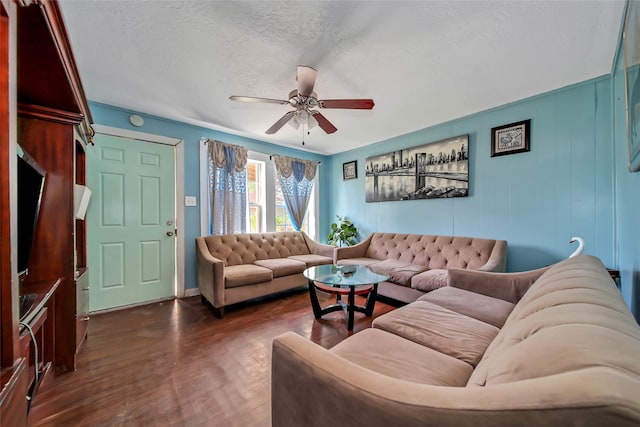 living room featuring dark wood-type flooring, a textured ceiling, and ceiling fan