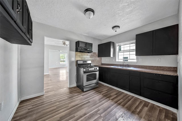 kitchen with sink, gas stove, wood-type flooring, and a wealth of natural light