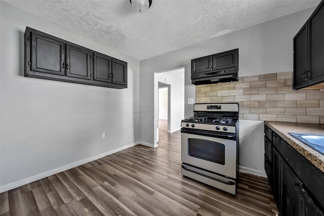 kitchen featuring decorative backsplash, stainless steel range with gas cooktop, a textured ceiling, and dark hardwood / wood-style flooring