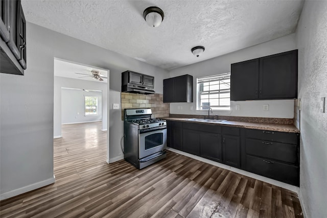 kitchen featuring a wealth of natural light, stainless steel range with gas cooktop, and dark hardwood / wood-style flooring