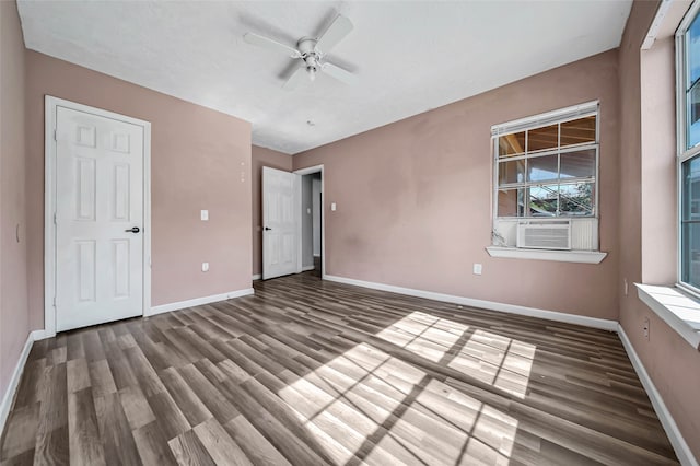 unfurnished bedroom with cooling unit, ceiling fan, and dark hardwood / wood-style flooring