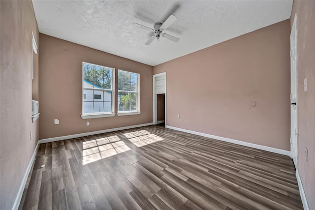 spare room featuring dark wood-type flooring, ceiling fan, and a textured ceiling